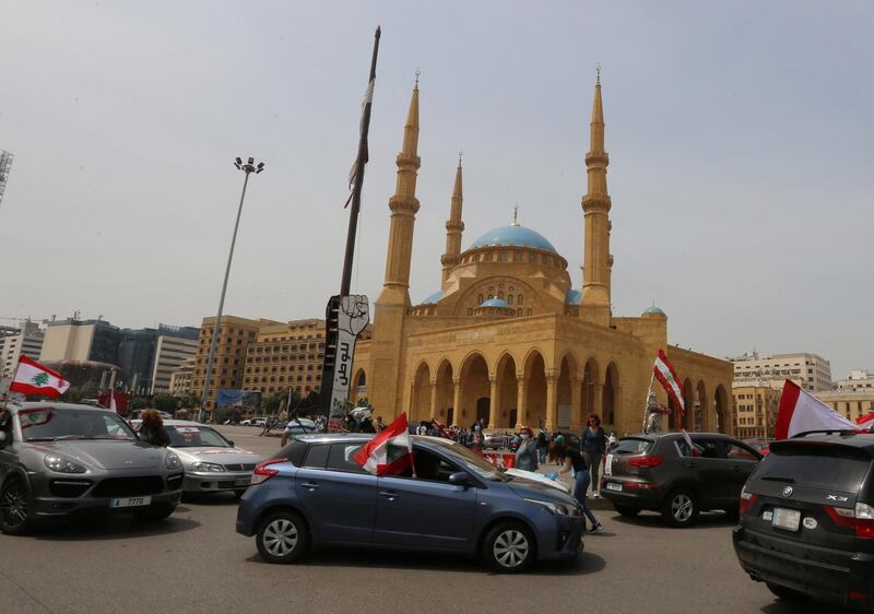 Anti-government demonstrators hold Lebanese flags as they protest in their cars, amid a countrywide lockdown to combat the spread of the coronavirus disease in Beirut, Lebanon.  Reuters