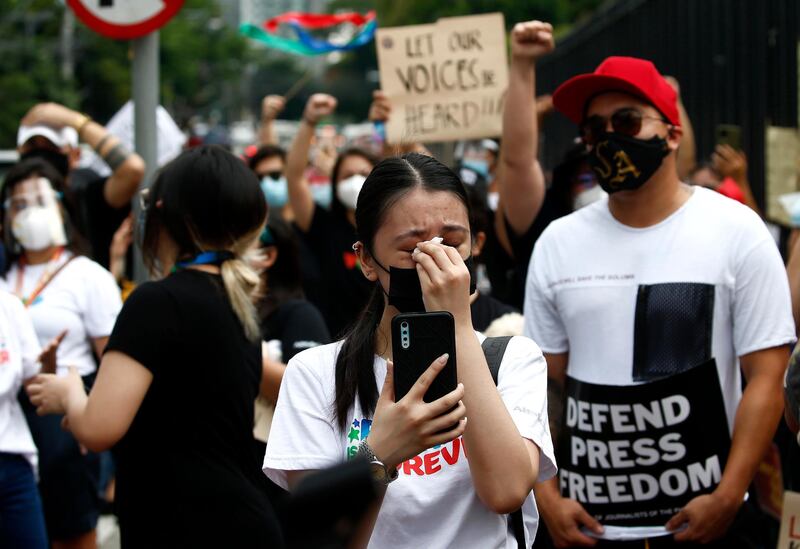 A Filipino reacts as supporters and employees gather outside the ABS-CBN network headquarters in Quezon City. EPA