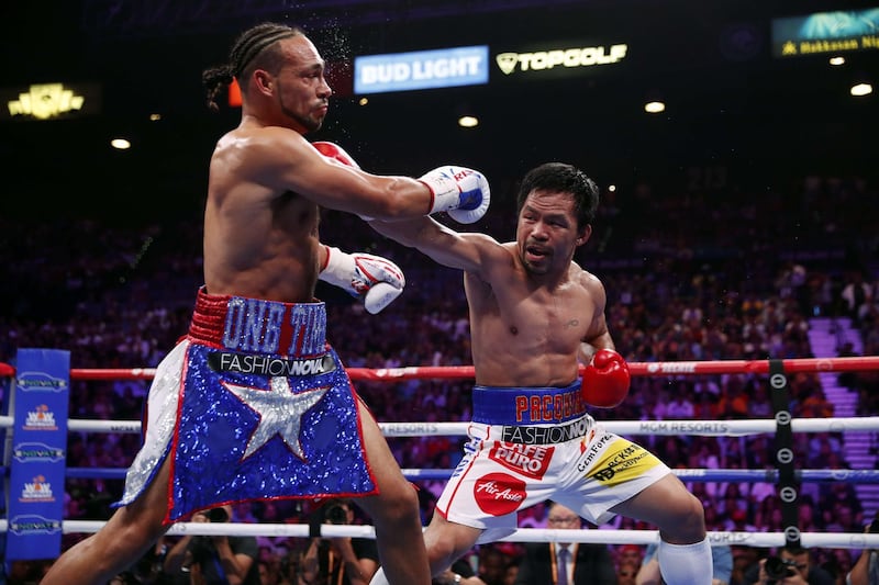 Manny Pacquiao (R) connects with a punch on Keith Thurman during their WBA welterweight title fight at MGM Grand Garden Arena. AFP