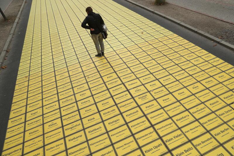 BERLIN, GERMANY - OCTOBER 01:  A man stops to look at city limits signs that form a walkway in the city center as part of celebrations to mark German Unity Day scheduled for Wednesday on October 1, 2018 in Berlin, Germany. All of Germany's 11,400 villages, towns and cities are represented in the winding path of signs through Berlin's government quarter. Germany will celebrate Unity Day (Tag der Deutschen Einheit) on October 3 with the the main event to take place this year in Berlin. (Photo by Sean Gallup/Getty Images)