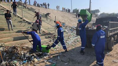 Residents clear rubbish on the banks of the Tigris river, which snakes through the capital. Sinan Mahmoud / The National