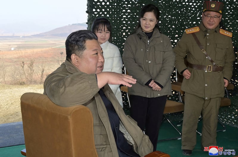 North Korean leader Kim Jong-un, with his wife Ri Sol-ju and their daughter looking on, discusses the launch of an intercontinental ballistic missile with military personnel. Reuters