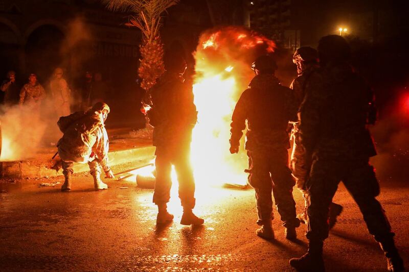 Members of the Lebanese army stand near burning tires during a protest against the lockdown and worsening economic conditions, amid the spread of the coronavirus disease (COVID-19), in Tripoli, Lebanon. Reuters