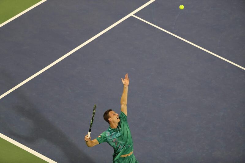 Fucsovics serves the ball to Federer. AFP