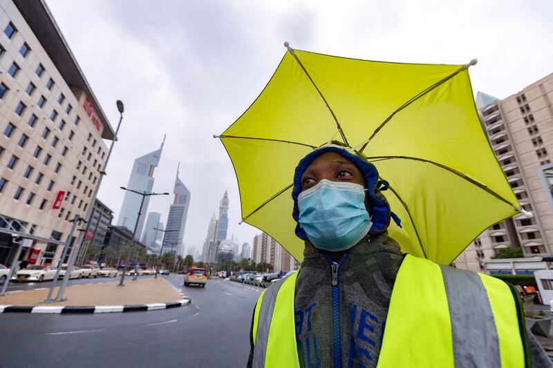 A worker shelters beneath an umbrella in Dubai. Chris Whiteoak / The National