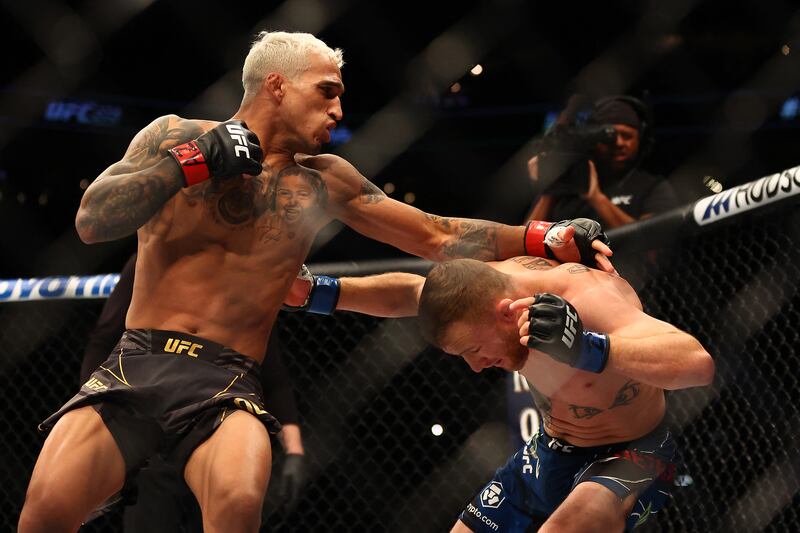 Charles Oliveira throws a punch at Justin Gaethje during their fight at UFC 274. Reuters