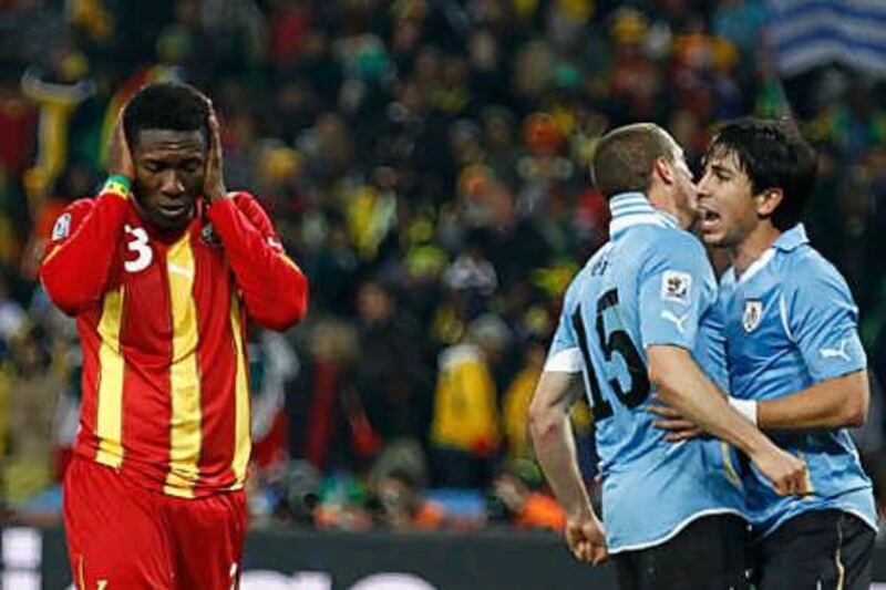 Asamoah Gyan, left, is distraught after missing his penalty in extra time.