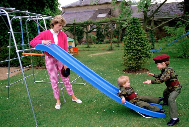 TETBURY, UNITED KINGDOM - JULY 18:  Princess Diana With Her Sons Prince William And Prince Harry Playing On A Slide In The Gardens Of Highgove House. The Boys Are Wearing The Uniforms Of The 1st Battalion Of The Parachute Regiment Of Which Their Father Is The Colonel-in-chief. Princess Diana Is Wearing A Gingham Style Pair Of Trousers.  (Photo by Tim Graham Photo Library via Getty Images)