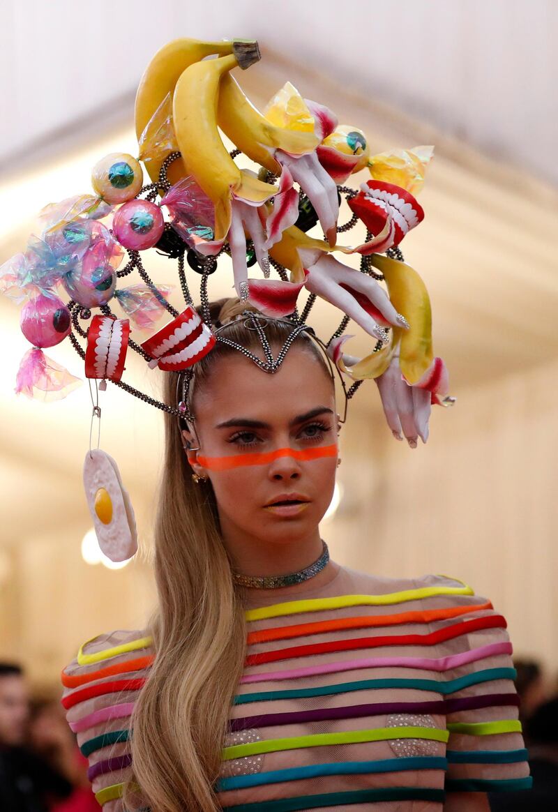 Model Cara Delevingne placed a raver-hued, Adam Ant-style band across her nose, nodding to her striped outfit. Reuters