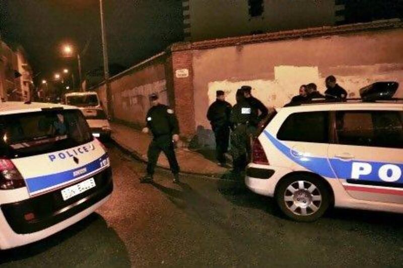 Police block a street during a raid on a house to arrest the suspect in a series of shootings in France that killed seven people.
