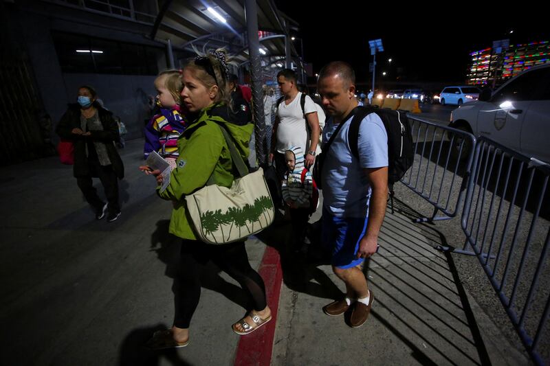 Ukrainians fleeing the Russian invasion of their homeland wait for a US  Customs and Border Protection agent before passing through a checkpoint to enter the US after authorities granted permission to remain in the country until 2023, at the San Ysidro Port of Entry of the US-Mexico border in Tijuana, Mexico. Reuters