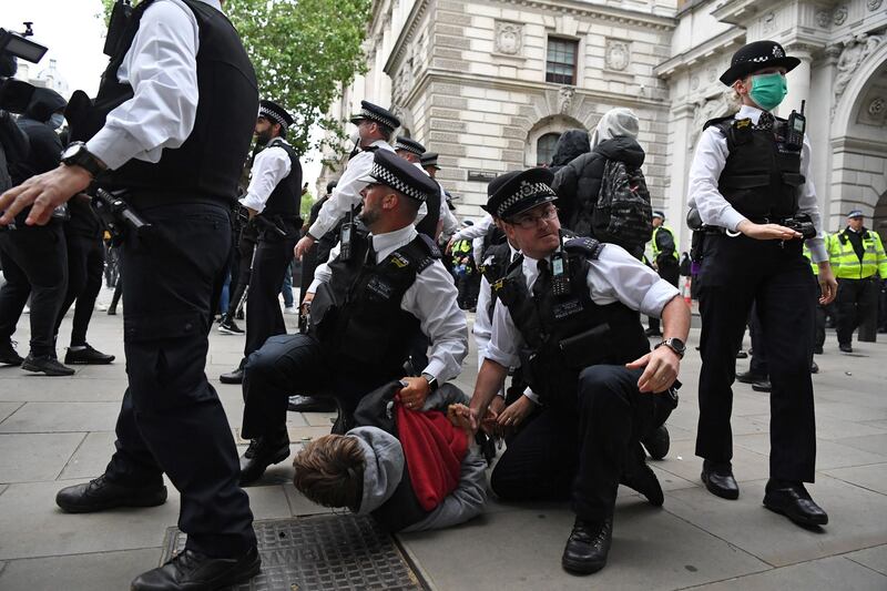 Police officers detain a protester near the Foreign Office. AFP