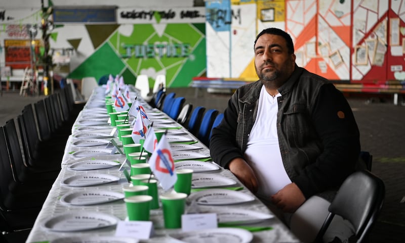 Former Grenfell Tower resident Nabil Choucair, who lost six members of his family in the west London fire, sits at an empty table for victims. PA