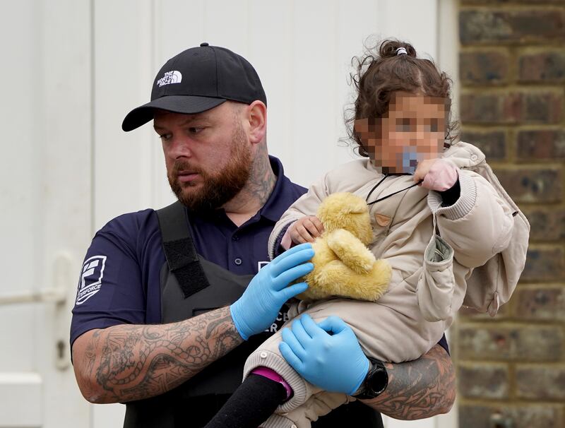 A little girl is carried by a security officer after arriving in Dover on June 7, 2022. PA