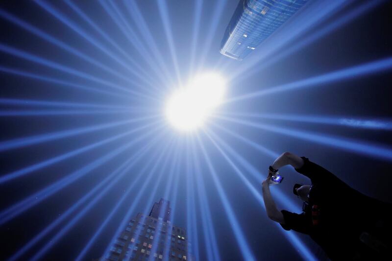 EMT with the Fire Department of New York and first responder Jason Butscher takes a photo while standing within the Tribute In Light installation as it is illuminated over lower Manhattan marking the 17th anniversary of the 9/11 attacks in New York City. Andrew Kelly/Reuters
