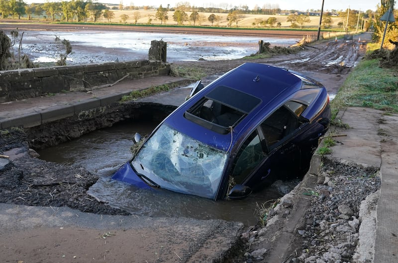 A car stranded on the remains of a washed away bridge near Dundee in Scotland. PA