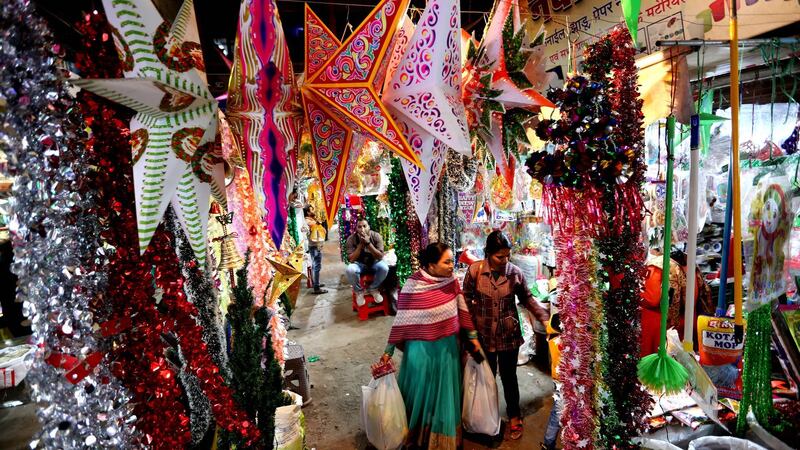 People walk between decorative items ahead of Christmas in Bhopal, India.  EPA