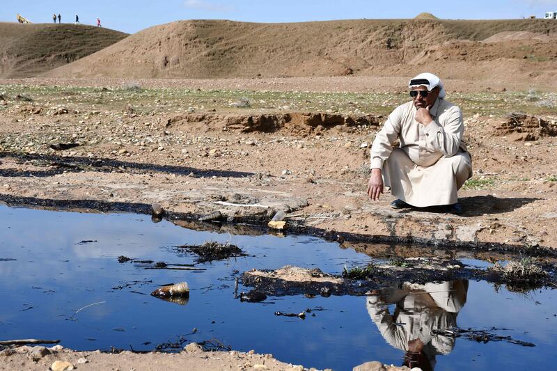 An Iraqi farmer checks an oil spill on agricultural land in the region of Hamrin, in Salaheddin province. AFP