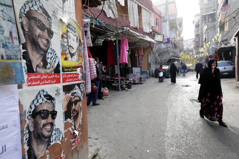 A picture taken on December 21, 2017 shows posters of late Palestinian leader Yasser Arafat plastered on a wall as residents walk past them down a street in the Burj al-Barajneh camp, a southern suburb of the Lebanese capital Beirut. - More than 174,000 Palestinian refugees live in Lebanon, authorities announced on December 21, in the first-ever census of its kind for a country where demographics have long been a sensitive subject.
The census was carried out by the government's Lebanese-Palestinian Dialogue Committee in 12 Palestinian camps as well as 156 informal "gatherings" across the country. (Photo by ANWAR AMRO / AFP)