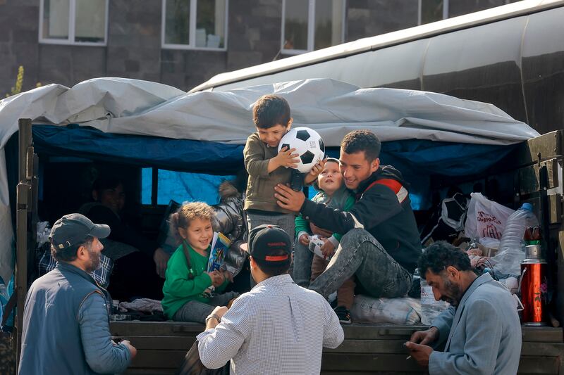 A family from Nagorno-Karabakh are helped as they leave a truck with their belongings after arriving at Goris. AP