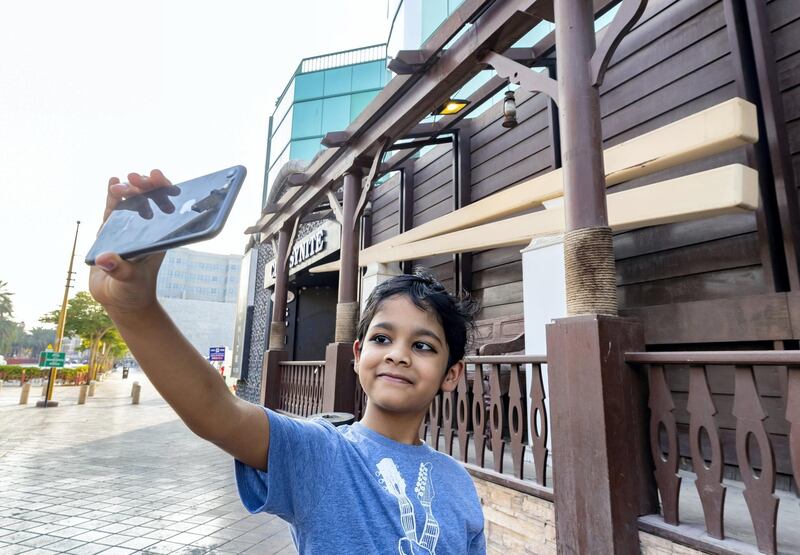Dubai, United Arab Emirates - July 07, 2019: Krishna 5 takes a selfie with the worldÕs largest chopsticks outside the Marco Polo hotel. Sunday the 7th of July 2019. Deira, Dubai. Chris Whiteoak / The National