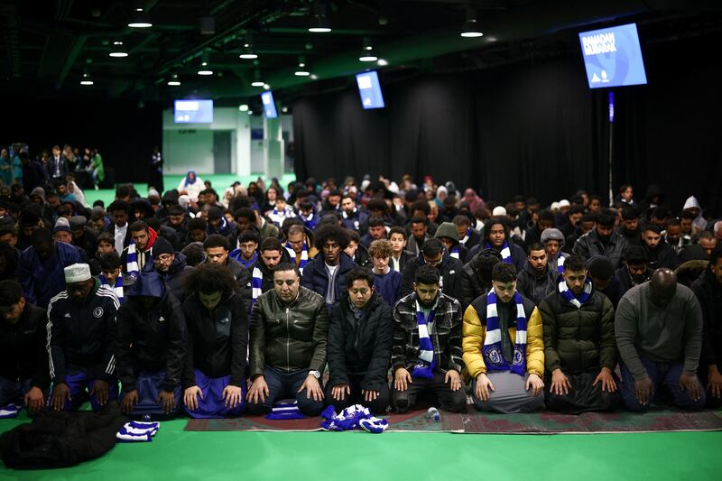 People pray at Stamford Bridge stadium. Reuters