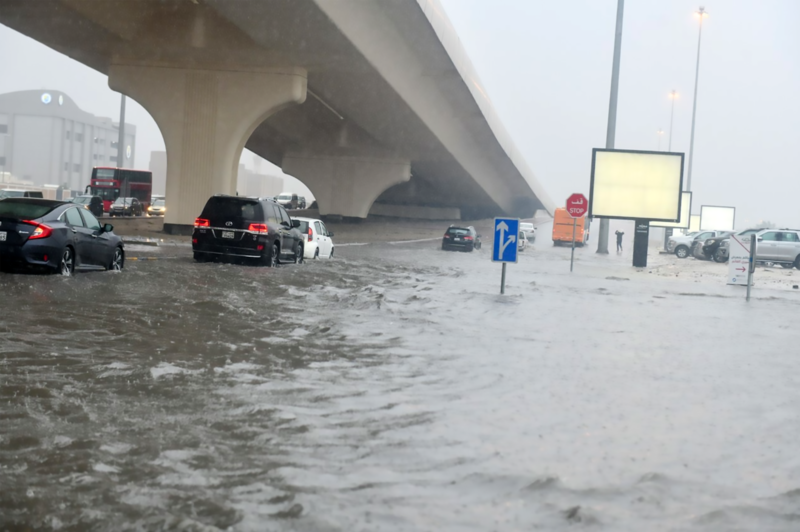 Drivers try to pass a flooded road. Kuwait News Agency