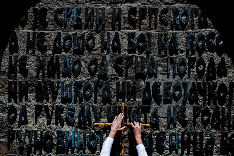 A Serbian man fixes candles to a wall of the Gazimestan memorial during a ceremony marking the historic "Battle of Kosovo" at a memorial in Gazimestan, on the outskirts of Pristina on June 28. The ceremony marks the Battle of Kosovo in 1389 when the Serbian army was defeated by the Ottoman Empire. Armend Nimani / AFP