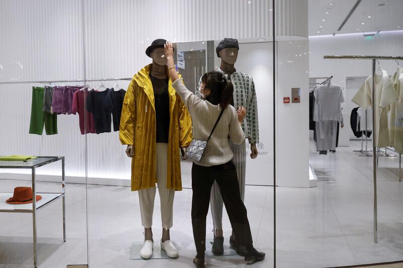 A staff member arranges the clothing on a mannequin in a boutique in a department store following an outbreak of the coronavirus disease in Beijing, China. REUTERS