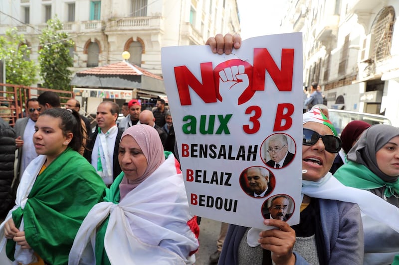 epa07496030 Algerian protester holds a banner against interim president Abdelkader Bensalah, interior minister Tayeb Belaiz and prime minister Noureddine Bedoui during a protest, in Algiers, Algeria, 10 April 2019. Algerian protesters took to the street after Algerian lawmakers of the two houses of the Parliament on 09 April named Bensalah as interim president after the resignation of Abdelaziz Bouteflika on 02 April following the constitutional rules.  EPA/MOHAMED MESSARA