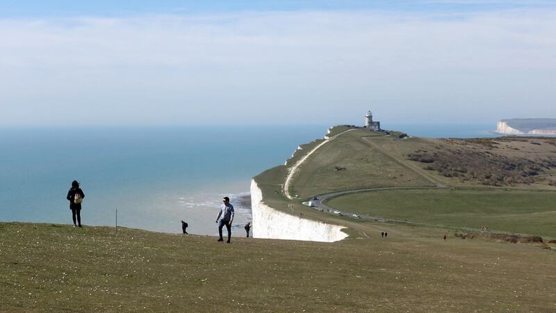 People walk along Beachy Head, as the spread of the coronavirus continues, near Eastbourne, East Sussex, UK on April 5, 2020. Reuters