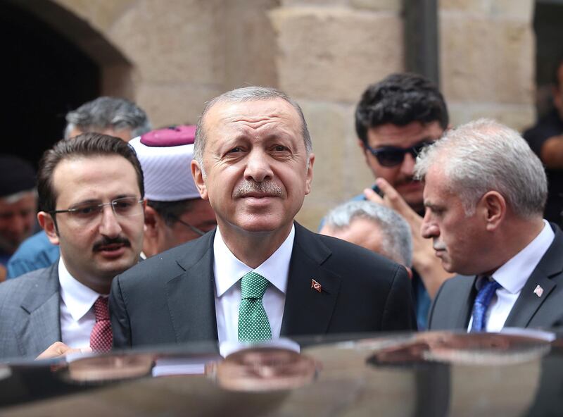 Turkey's President Recep Tayyip Erdogan listens to supporters after Friday prayers, in Bayburt, Turkey, Friday, Aug. 10, 2018. Turkey's Finance and Treasury Minister, son-in-law of Erdogan, Berat Albayrak will reveal a " new economic model " as the Turkish Lira currency has lost more than 30 percent of its value since the start of the year.(Presidential Press Service via AP, Pool)