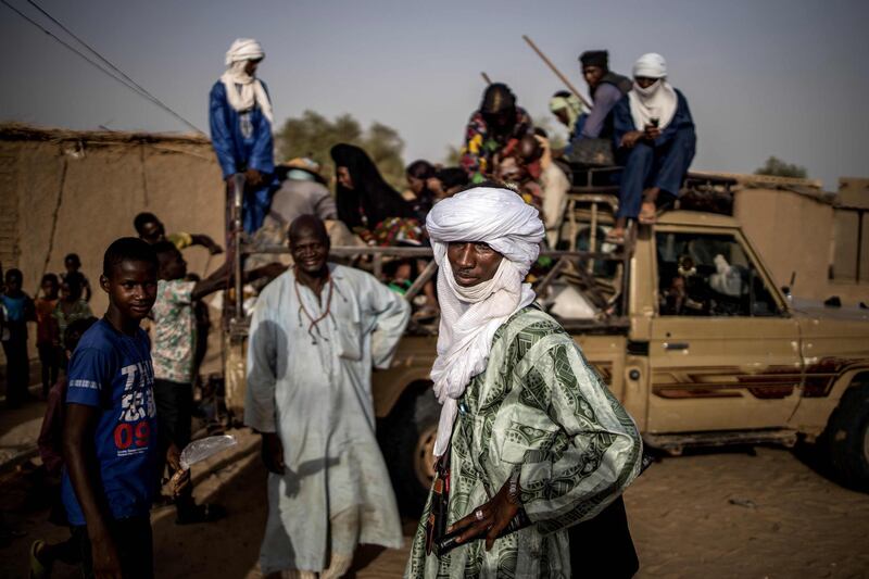 Wodaabe men gather at the weekly market in Bermo on June 25, 2019. The Wodaabe People, a sub-group of the Fulani, are nomadic cattle herders and traders in the wider Sahel region. Their migrations stretch from southern Niger, through northern Nigeria, northeastern Cameroon, southwestern Chad, and the western region of the Central African Republic. Higher temperatures, shifting winds and moisture levels that alter rainfall patterns, sandstorms, torrential rain -- all can change the quality or even the location of pasture on which migrating herders depend. This year, for the Fulani, has been relatively good. The herdsman were able to draw on stocks of animal feed to help them survive stress points, while timely rainfall on some areas of the migration trail helped tender young grass to grow. But whether this respite endures is the big question. / AFP / Marco LONGARI
