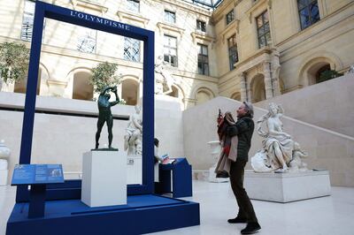 A visitor takes a picture of the bronze "The Finnish Discus Thrower" by Kostas Dimitriadis, at the Louvre Museum in Paris, on April 23.  AFP