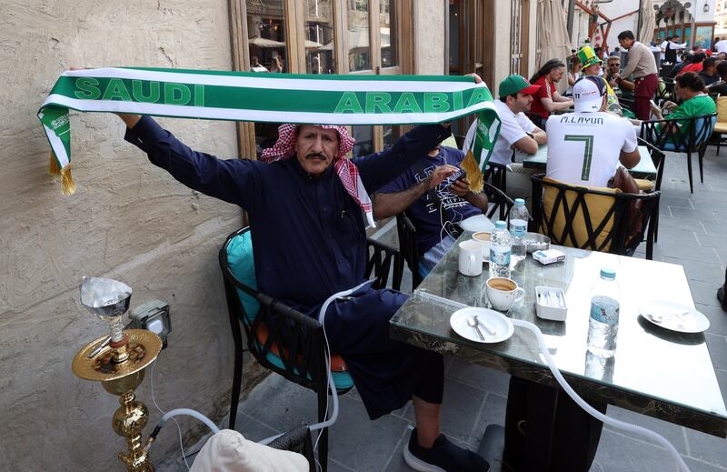 A fan of Saudi Arabia flies his team's colours at Souq Waqif in Doha. EPA