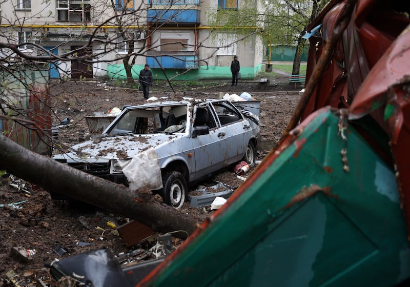 Local residents view a destroyed car next to a multi-storey building in Lysychansk. AFP