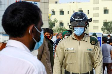A police officer wears a smart helmet as he uses it to check the temperature of workers during the outbreak of the coronavirus disease in Dubai. Reuters