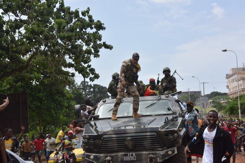 People celebrate in the streets with members of Guinea's armed forces . AFP