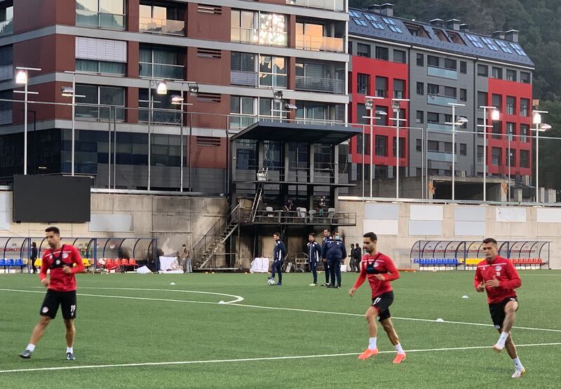 The Andorra national team train in front of the charred stand.  AP