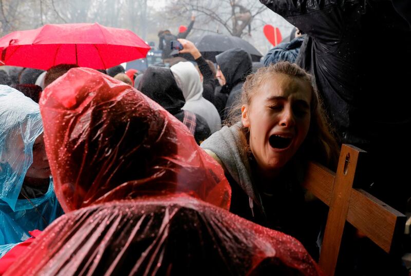 A young woman with a crucifix cries as police use a water cannon to disperse protesters demonstrating against the coronavirus lockdown measures imposed by the German government, close to the Reichstag building in Berlin.  AFP