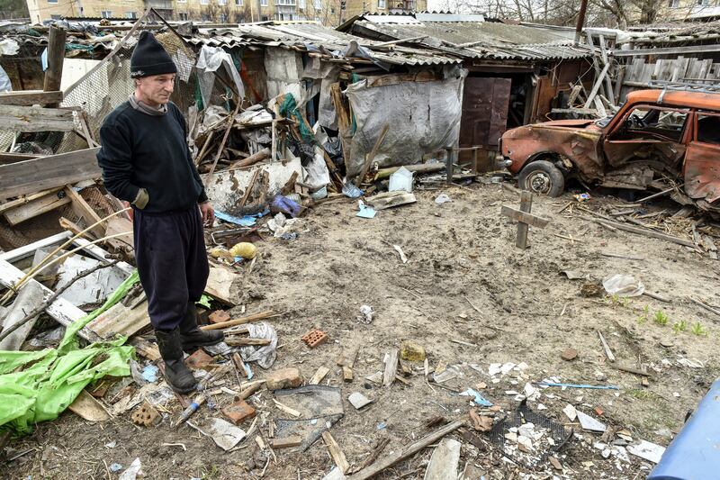 Local citizen Oleksandr, 55, looks at the grave of his neighbour in the backyard of his private house in Hostomel in Kyiv. EPA