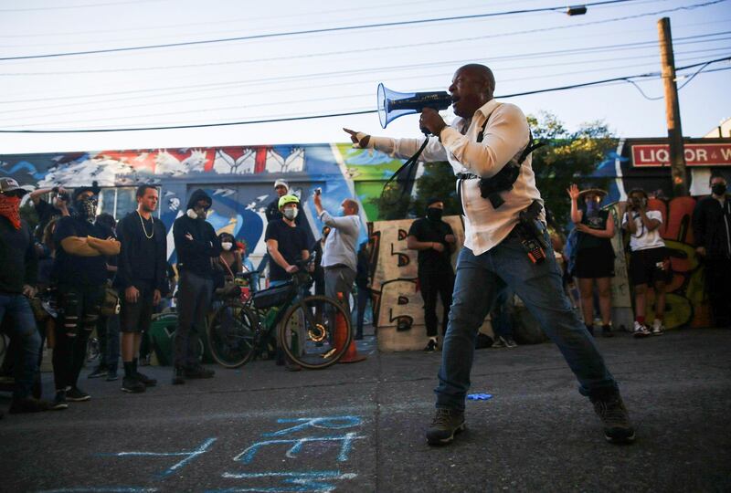 Harry Hearns of the "community response team" talks to other protesters as they discuss strategies outside the Seattle Police Department's East Precinct in Seattle, Washington. Reuters