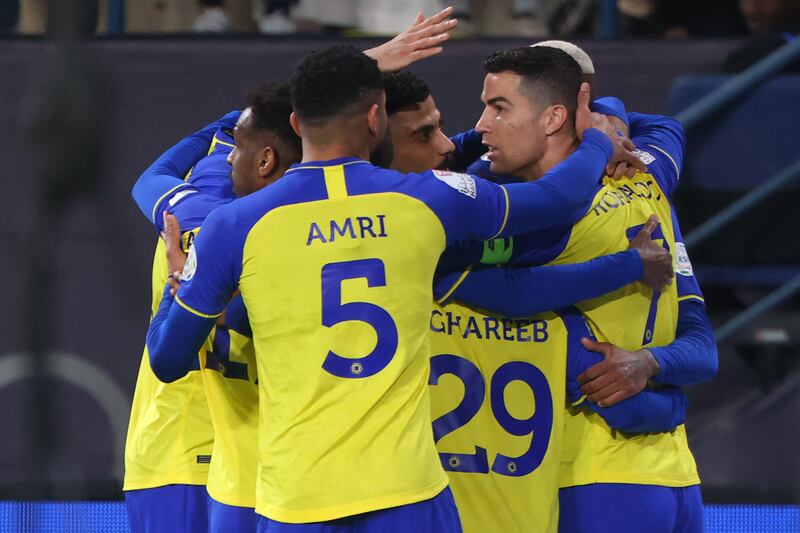 Nassr's Portuguese forward Cristiano Ronaldo celebrates with teammates after they scored their first goal during the Saudi Pro League football match between Al-Nassr and Al-Ettifaq at the King Fahd Stadium in the Saudi capital Riyadh on January 22, 2023.  (Photo by Fayez NURELDINE  /  AFP)