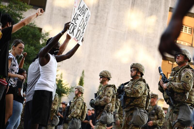National Guards form a line in front of "Black Lives Matter" protestors in Tulsa, Oklahoma where Donald Trump holds a campaign rally at the BOK Center. AFP