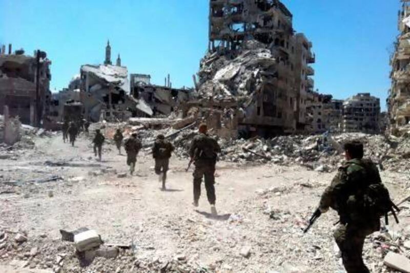 Syrian government forces patrol in the Khaldiyeh neighbourhood of Homs, which they have recaptured.