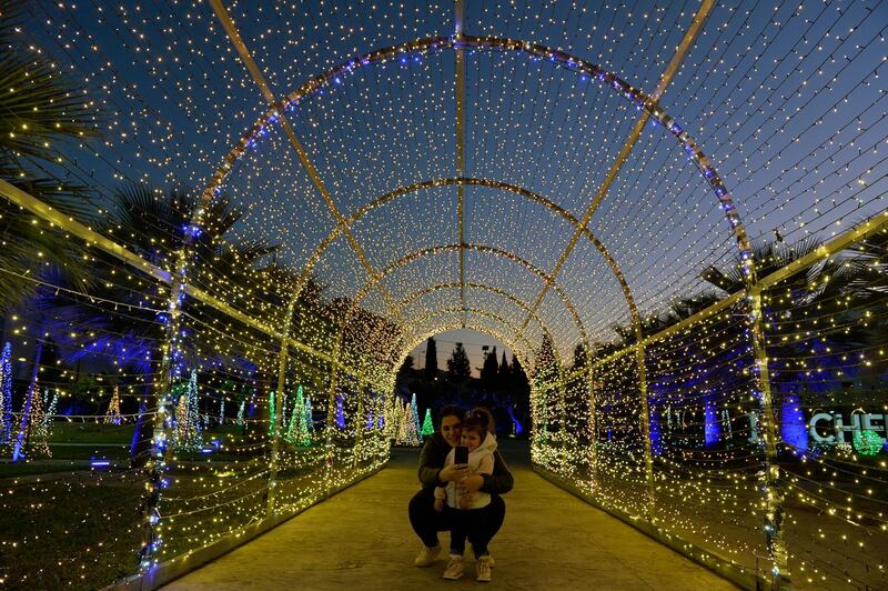 A woman takes a selfie with her daughter under Christmas lights installations in the northern coastal town of Chekka, Lebanon. EPA