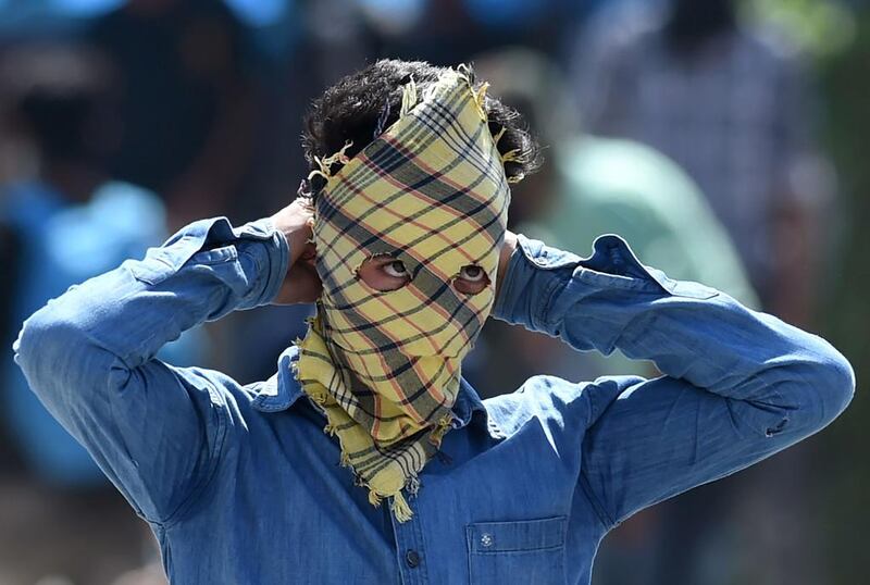 A masked Kashmiri protester looks towards Indian government forces during clashes after congregational prayers outside the Jamia Masjid in Srinagar. Tauseef Mustafa / AFP / May 5, 2017