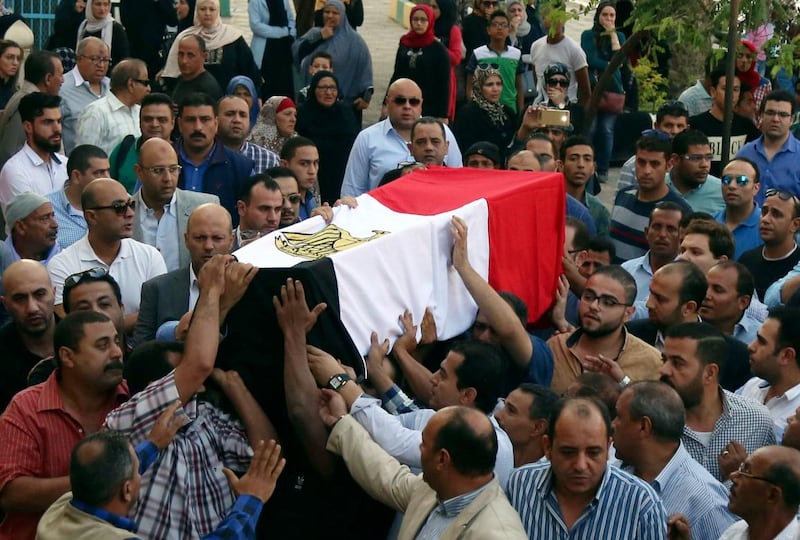 People carry the coffin, covered with the an Egyptian flag, of police captain Ahmed Fayez who was killed in a gun battle in al-Wahat al-Bahriya area in Giza province, about 135 kilometers (84 miles) southwest of Cairo, during his funeral at Al-Hosary mosque, in Cairo, Egypt, Saturday, Oct. 21, 2017. At least 54 policemen, including 20 officers and 34 conscripts, were killed when a raid on a militant hideout southwest of Cairo escalated into an all-out firefight, authorities said Saturday, in one of the single deadliest attacks by militants against Egyptian security forces in recent years. (AP Photo/Alaa Elkassas)