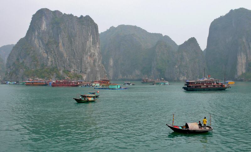 Tourist junks and fishermen are seen cruising in the Halong bay on the northeastern coast of Vietnam 09 December 2007. Halong Bay  is a UNESCO World Heritage site located in Quang Ninh province, Vietnam, it features thousands of limestone karsts and isles in various sizes and shapes. AFP PHOTO VOISHMEL