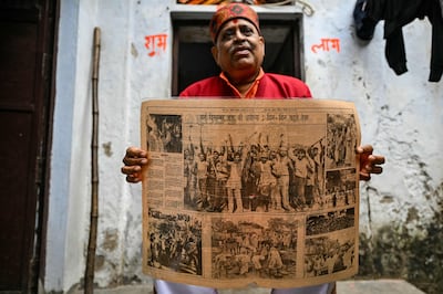 A man who took part in dismantling the Babri Masjid mosque in 1992 shows a newspaper article about the incident, bearing his photograph. AFP 